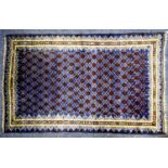 EASTERN RUG with all-over pattern of rows of dark red/brown small diamond shapes on a dark blue