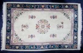 WASHED CHINESE EMBOSSED ALL-WOOL CARPET with circular centre medallion, on an ivory field with a