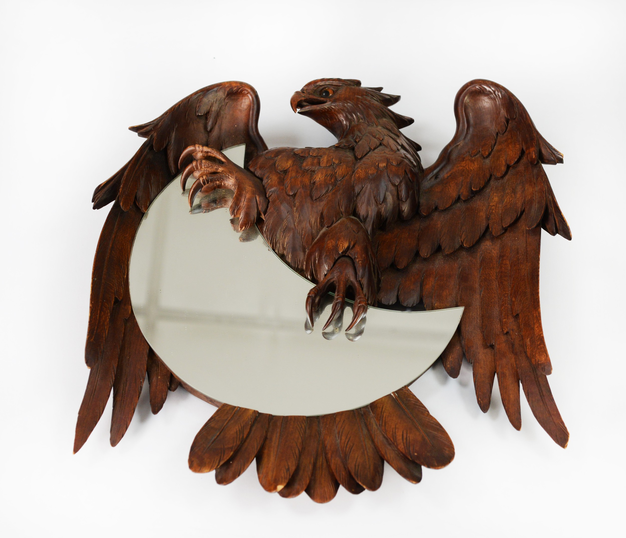 BLACK FOREST STYLE CARVED FRUITWOOD CRESCENT MIRROR, the bas relief carved spread-eagle clasping the