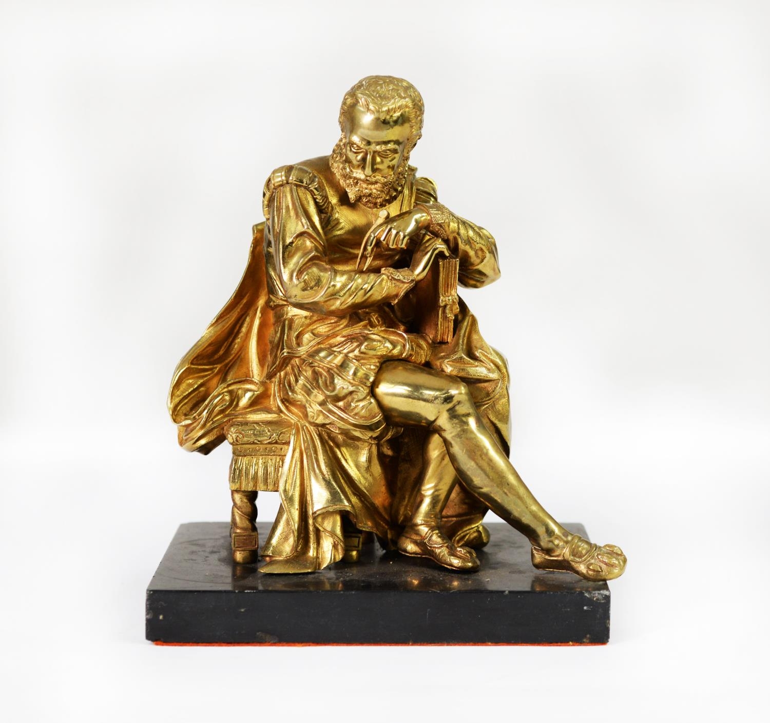 EARLY 20th CENTURY GILT BRASS FIGURE OF AN ELIZABETHAN GENTLEMAN SEATED ON A STOOL, possibly