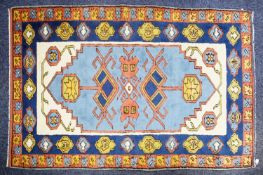 KARS, TURKISH WOOL RUG with geometric triple medallion pattern with pendants on a sky blue field