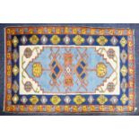 KARS, TURKISH WOOL RUG with geometric triple medallion pattern with pendants on a sky blue field