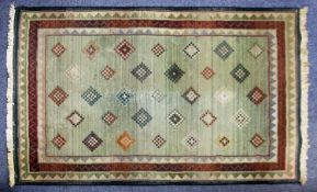EASTERN SMALL CARPET, machine made with all-over chequered diamond pattern, on a pale green