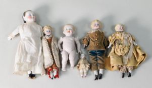 FIVE LATE NINETEENTH CENTURY GERMAN GLAZED AND BISQUE PORCELAIN DRESSED MINIATURE DOLLS with ceramic