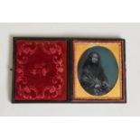 VICTORIAN COLOUR TINTED AMBROTYPE PHOTOGRAPH OF A SEATED LADY, in black costume in the embossed