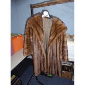 LIGHT BROWN FULL-LENGTH FUR COAT with deep shawl collar, slit pockets, interior silk tie fastening