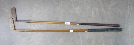 TWO BYGONE HICKORY SHAFTED GOLF PUTTERS, one in brass, stamped: ‘HALLEY’, with later ‘SWING RITE,