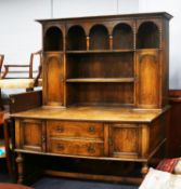 TWENTIETH CENTURY CARVED DARK OAK DRESSER, the raised plate rack with boarded back, galleried centre