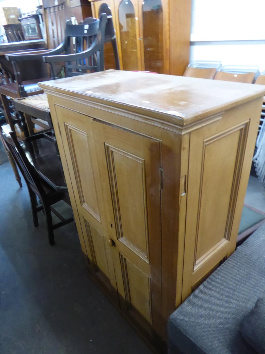 A BROWN PAINTED TWO DOOR STORE CUPBOARD