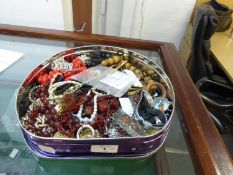 A CADBURY’S BISCUIT TIN, CONTAINING COSTUME JEWELLERY, COSTUME NECKLACES AND A LADY’S WRISTWATCH