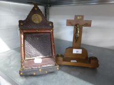 AN OAK AND BRASS CRUCIFIX, ON OBLONG BASE WITH TWO BRASS MOUNTED CANDLE SCONCES AND A LEATHER