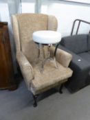 MODERN FIRESIDE WINGED BACK ARMCHAIR ON CABRIOLE FRONT SUPPORTS AND A STYLISH CIRCULAR TOPPED