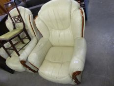 A PAIR OF SEMI-WINGED LOUNGE CHAIRS, UPHOLSTERED AND COVERED IN CREAM HIDE, THE ARMS HAVING MAHOGANY