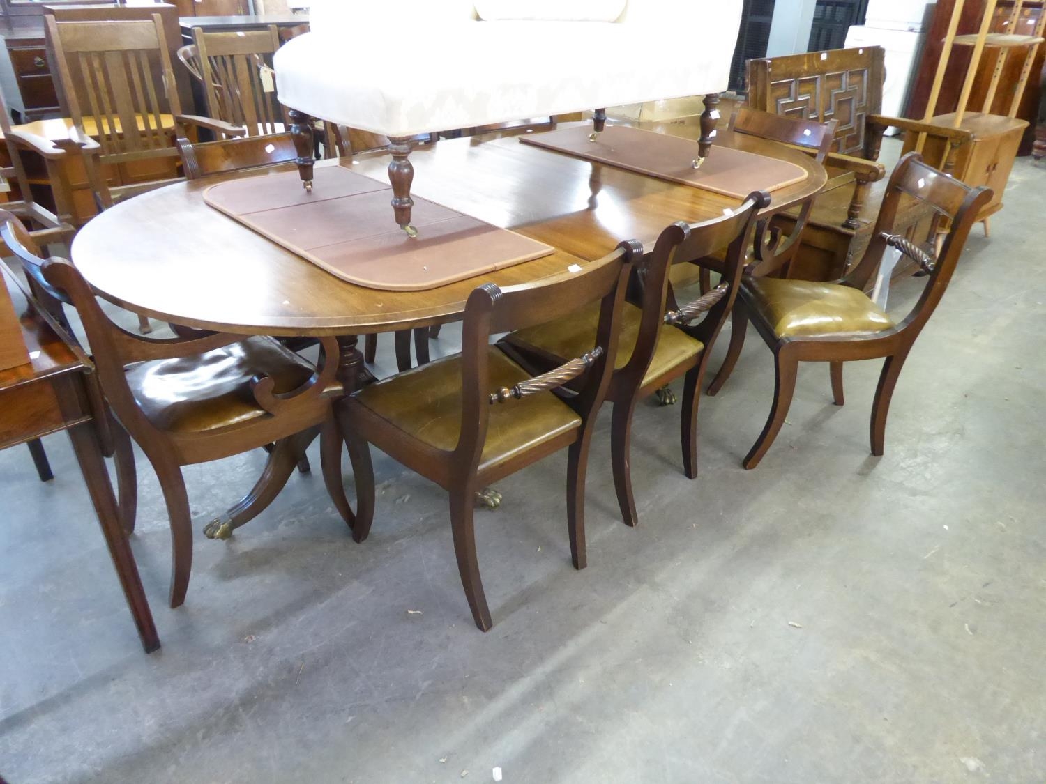 A MAHOGANY REPRODUCTION TWIN PILLAR DINING TABLE, WITH EXTRA LEAF AND A SET OF EIGHT (6 + 2)