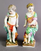 A PAIR OF 19TH CENTURY BERLIN FIGURE GROUPS, modelled as a young girl with dog and a young boy
