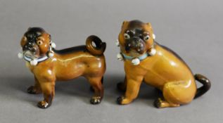TWO 19TH CENTURY GERMAN PORCELAIN PUG FIGURES, the larger example seated and with a blue ribbon