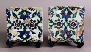A PAIR OF ISNIK TILES, decorated with blue, green and brick red floral decoration to a tin glaze, 6"