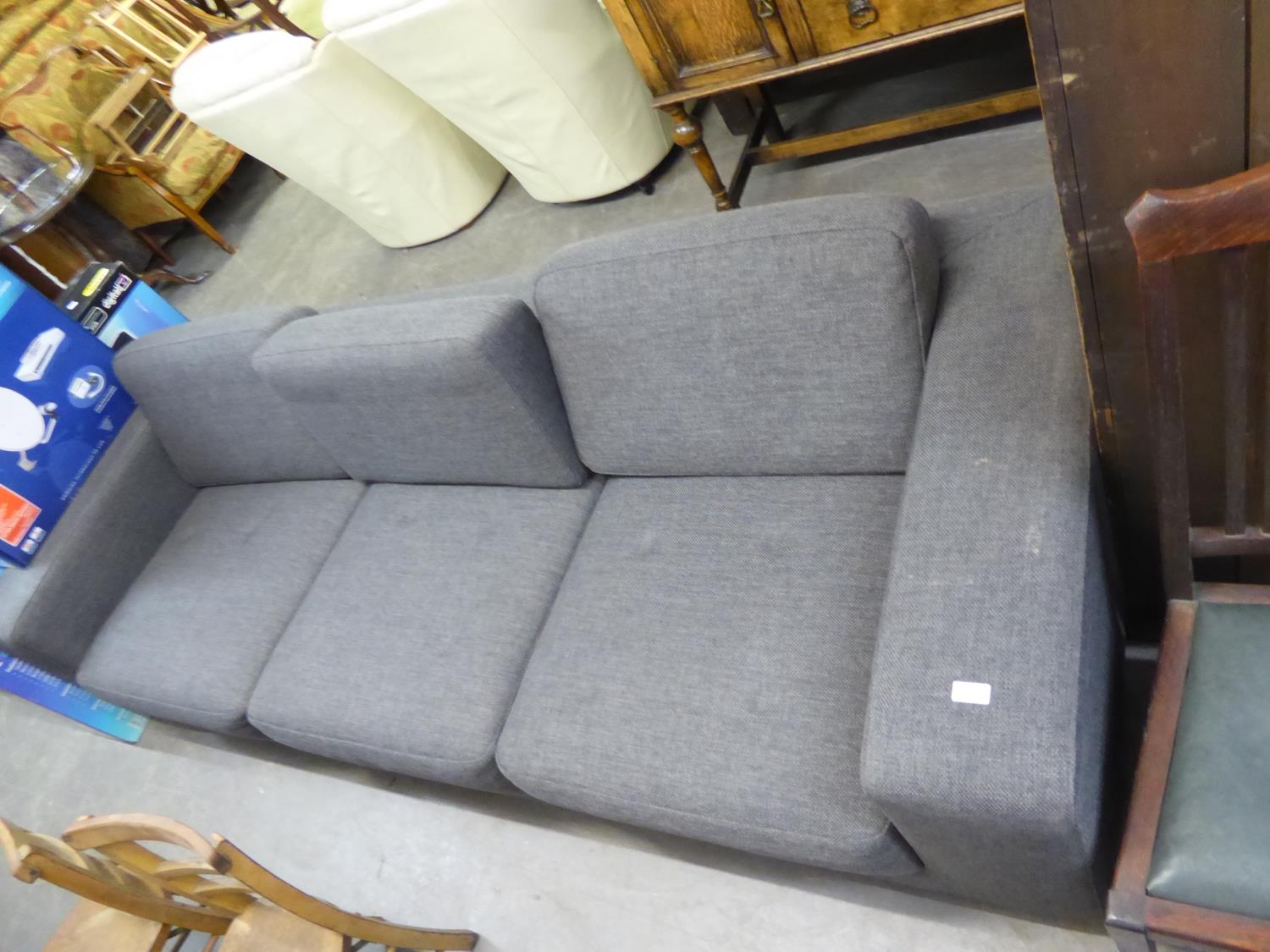 A GREY FABRIC THREE SEATER SOFA WITH LOW BACK HAVING THREE LOOSE CUSHIONS, RAISED ON CHROME FEET, (