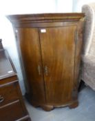 A NINETEENTH CENTURY MAHOGANY BOW FRONTED CORNER CUPBOARD