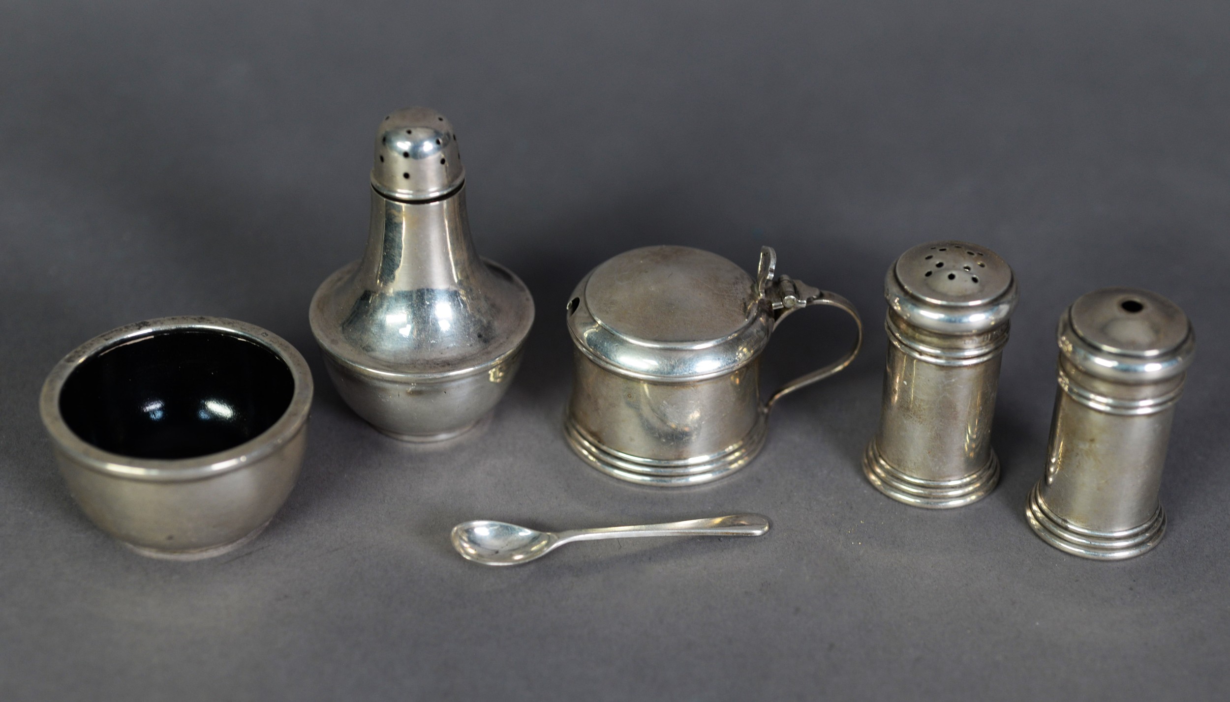 GEORGE V THREE PIECE SILVER CONDIMENT SET, of cylindrical form with moulded borders and blue glass