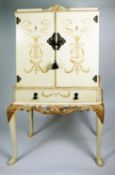 A CREAM ENAMEL COCKTAIL CABINET, with gold painted foliate scroll and lyre decoration, two doors