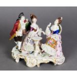 ITALIAN CAPO DI MONTE CHINA LACE GROUP of a courtier and two seated ladies round a small table, on