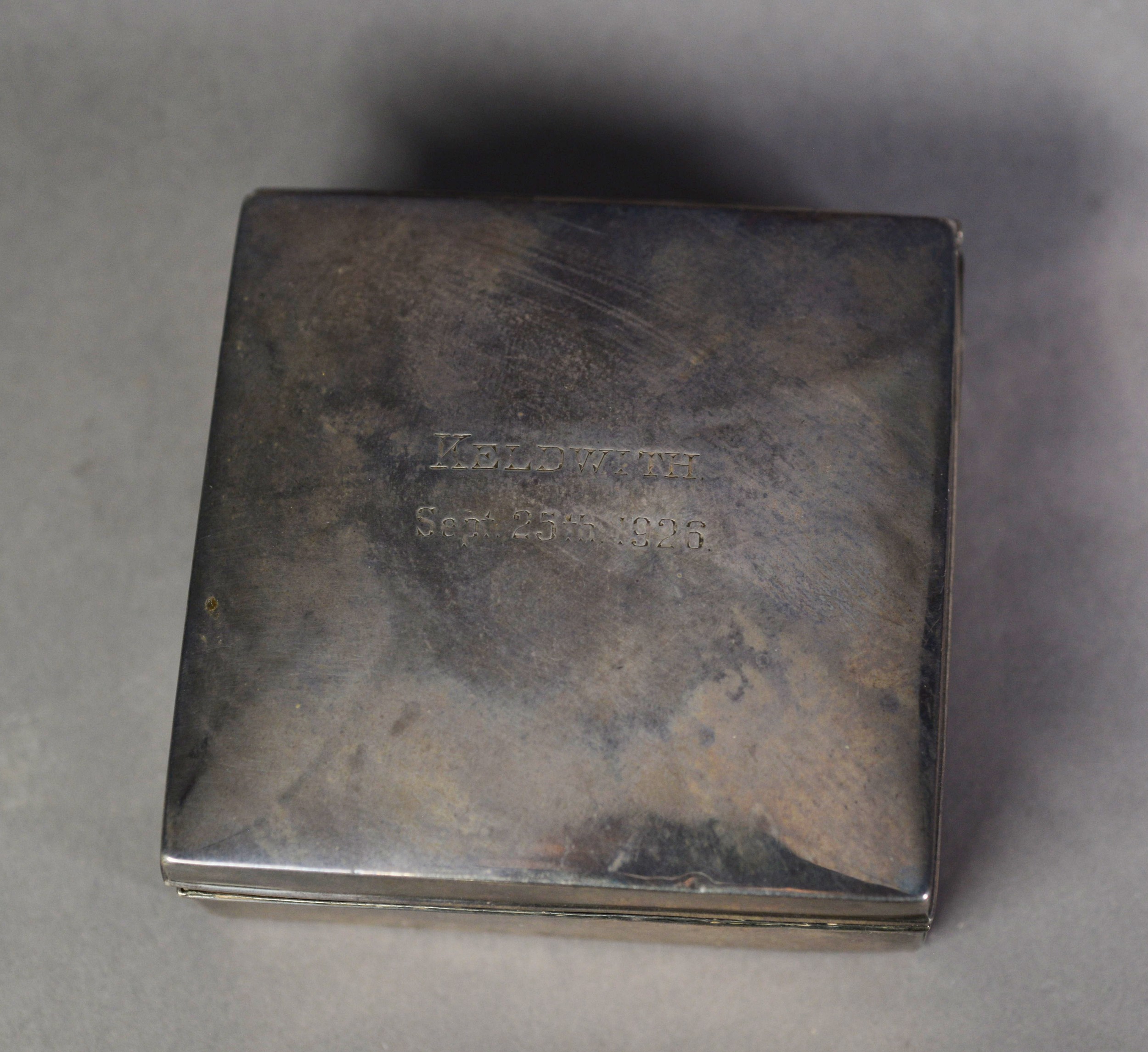 GEORGE V PRESENTATION SILVER CLAD TABLE CIGARETTE BOX, of square form with hardwood lined interior
