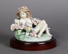 LLADRO, SPANISH PORCELAIN FIGURE OF A NYMPH reclining amongst a bed of flowers, 4 ½” (11.4cm)