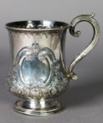 VICTORIAN EMBOSSED SILVER TANKARD, of footed, baluster form with scroll handle, decorated with