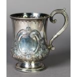 VICTORIAN EMBOSSED SILVER TANKARD, of footed, baluster form with scroll handle, decorated with