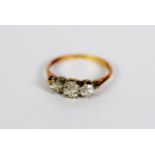 18ct GOLD AND PLATINUM RING set with three old cut round diamonds, the centre stone approximately .