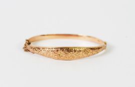 GEORGE V 9ct GOLD HINGE-OPENING HOLLOW BANGLE, the slightly domed tapering top foliate chased,