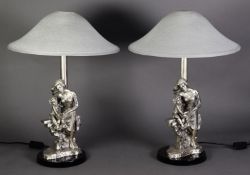 TWO CASED SILVER FIGURAL BEDSIDE LAMPS, in the form of a young woman seated on a wall reading to a