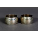 VICTORIAN PAIR OF ENGRAVED SILVER NAPKIN RINGS, of swollen form, decorated with leaves and vacant