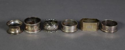 SIX EDWARD VII AND LATER SILVER NAPKIN RINGS, including a PLAIN PAIR WITH RAISED BORDERS, an