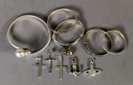 THREE CHILD'S STERLING SILVER SPRUNG BANGLES and ANOTHER with two pendant bells; a small silver