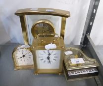 A SATIN BRASS AND GLASS ARCH SHAPED BATTERY ALARM CLOCK A SMALL MILESTONE SHAPED SATIN BRASS