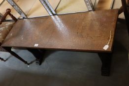 AN OBLONG BRASS TOPPED COFFEE TABLE WITH TRESTLE BASE