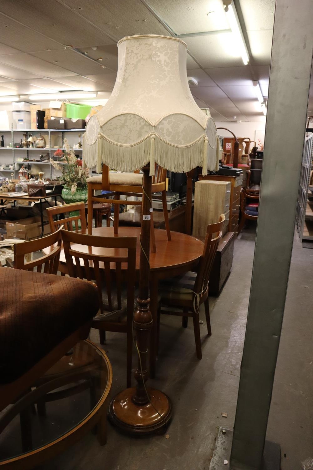 A WALNUT STANDARD LAMP WITH BALUSTER COLUMN AND CIRCULAR BASE WITH PAD FEET AND THE WHITE SILK,