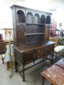 1930'S OAK PURITAN STYLE DRESSER WITH TWIN CUPBOARD DELFT RACK AND CENTRAL BANK OF TWO DRAWERS ON