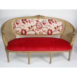 MOULDED AND CARVED GILT WOOD FRAMED FRENCH THREE SEATER SETTEE, with floral cresting, curved ends