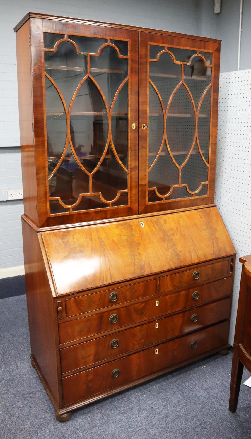 LATE GEORGIAN FIGURED AND CROSSBANDED MAHOGANY BUREAU BOOKCASE, the upper section with a pair of
