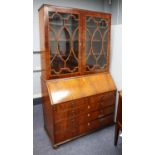 LATE GEORGIAN FIGURED AND CROSSBANDED MAHOGANY BUREAU BOOKCASE, the upper section with a pair of