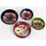 FOUR WALTER MOORCROFT TUBE LINED POTTERY SMALL DISHES, comprising: TWO IN THE ANENOME PATTERN ON
