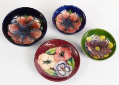 FOUR WALTER MOORCROFT TUBE LINED POTTERY SMALL DISHES, comprising: TWO IN THE ANENOME PATTERN ON