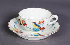 FIRST PERIOD WORCESTER PORCELAIN TEACUP AND SAUCER, each fluted and painted in bright enamels with