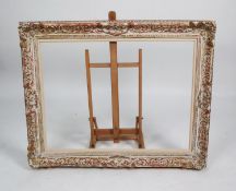 LARGE 20th CENTURY SWEPT ROCOCO PICTURE FRAME with antiqued gilt and white finish, 31in x 39in (79 x