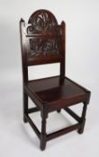 EIGHTEENTH CENTURY CARVED OAK SIDE CHAIR, the panelled back with arced top, carved in relief with