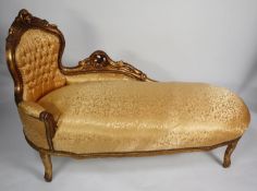 ORNATE GILT FRAMED CHAISE LONGUE, the show wood frame enclosing a deep buttoned back above a