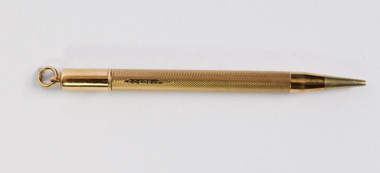 9ct GOLD SLIM PROPELLING PENCIL with engine turned decoration, ring hanger to the top, 4in (10cm)